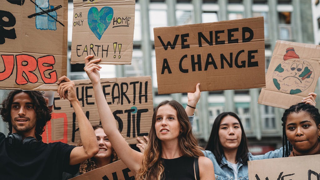 Young people holding up signs in climate change protest