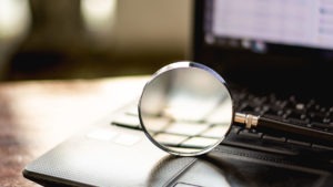 Image of magnifying glass on top of laptop