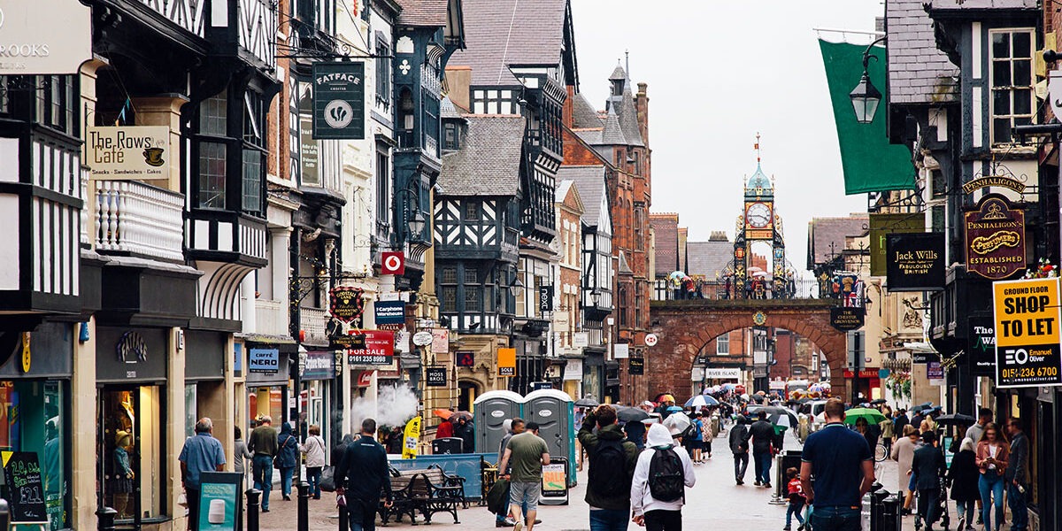 Image of high street with rows of shops with people walking