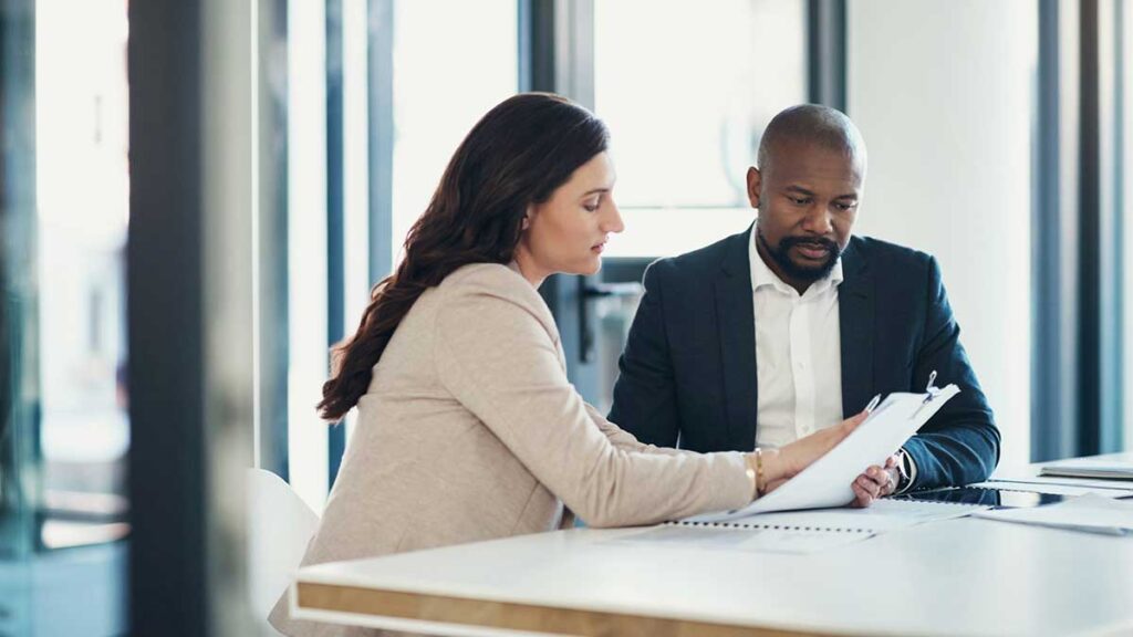 Business meeting, man and woman discussing paperwork