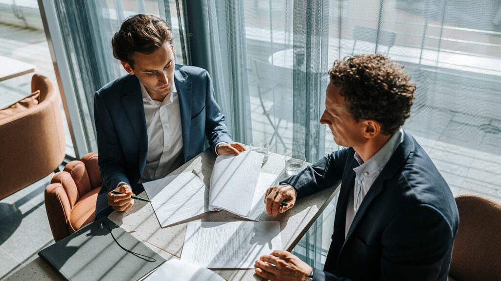 Business professionals in a meeting looking through contracts